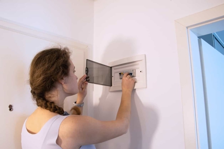 woman checking a home circuit breaker panel